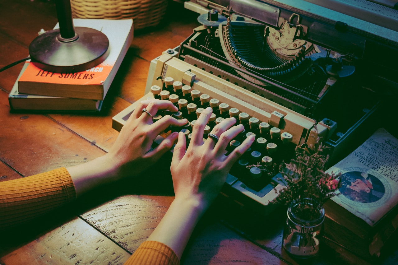 fingers typing on typewriter